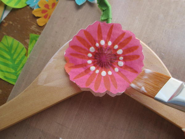 Working quickly, pick up the flower with the brush and place carefully onto the glued section of the hanger. 