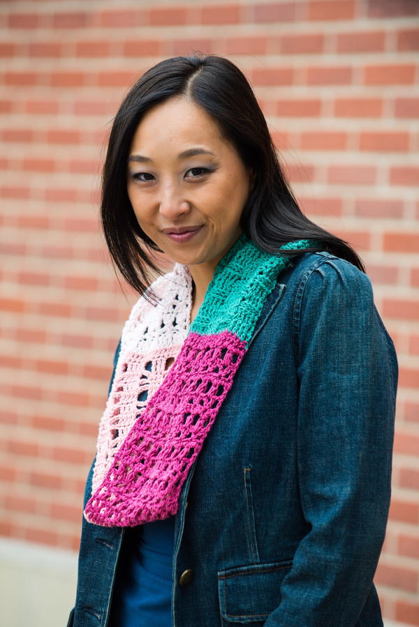 Image shows a woman wearing the Southwestern Sunset Crochet Sampler Scarf.