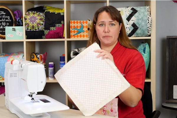 Image shows Carolina Moore holding the finished fabric swatch showing the grid design.