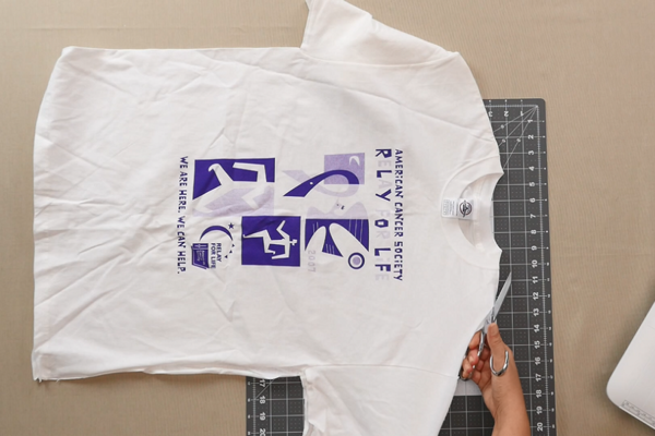 Image shows a shirt being cut.