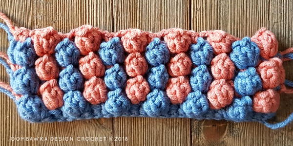Image shows the continuation of crocheting the popcorn stitch.