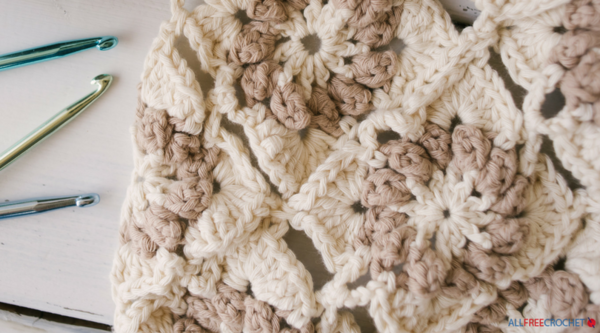 Image shows a finished crochet project at the right and crochet hooks on the left side.