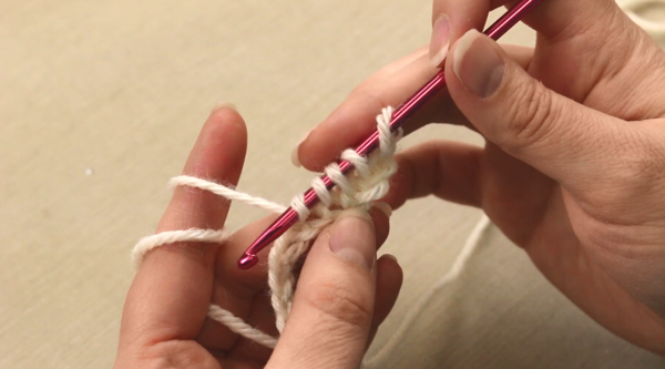Image shows the first step in Tunisian crochet: the Tunisian simple stitch (Tss).