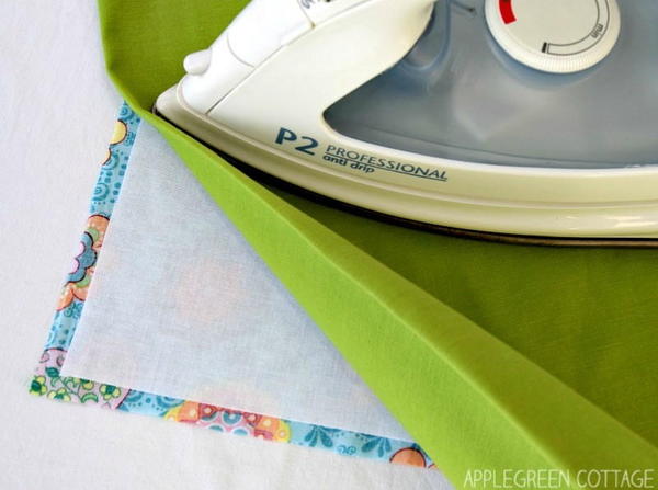 Image shows an iron pressing fabric onto fusible interfacing and is from our article: How To Apply Fusible Interfacing
