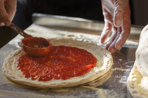 Spreading pizza sauce