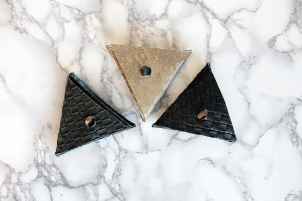 Image shows three of the no-sew triangle coin purses on a light marbled background.