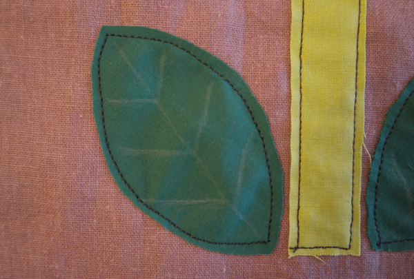 Image shows close-up of one embroidered leaf on the cushion. How to Embroider the Flowers - Step 1