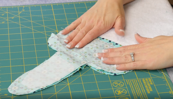 Image shows fabric pattern pieces being put right sides together over the terry cloth towel.