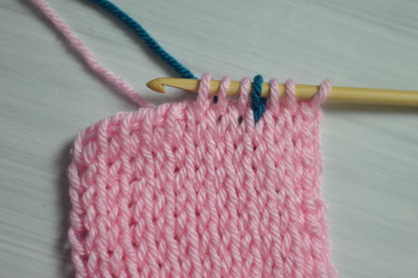 Image shows the first step for carrying colors in Tunisian crochet.