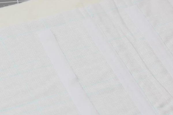 Image shows a piece of light fabric with blue lines and pieces of Velcro aligned to fit the lines. Image shows a piece of light fabric with blue lines and pieces of Velcro aligned to fit the lines.