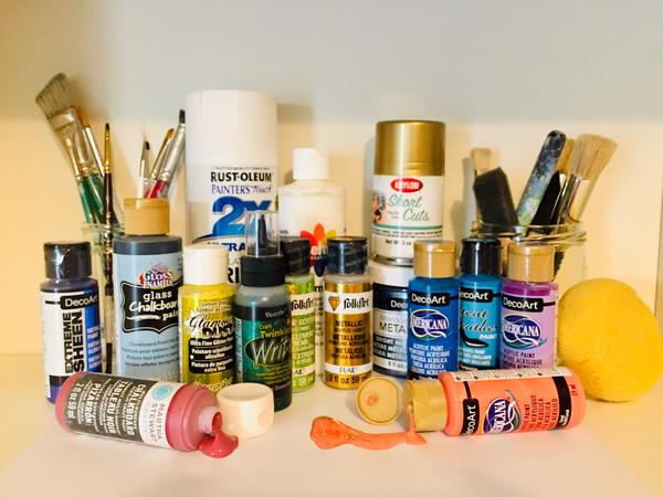 A variety of different craft paints, as well as brushes and tools