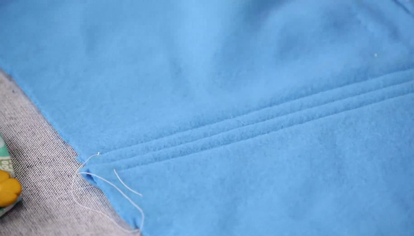 Image shows a piece of blue fleece with three straight decorative stitches running down the length of the fabric.