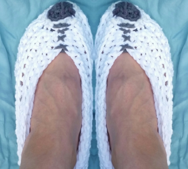Image shows one pair of the quick crochet slippers being worn.
