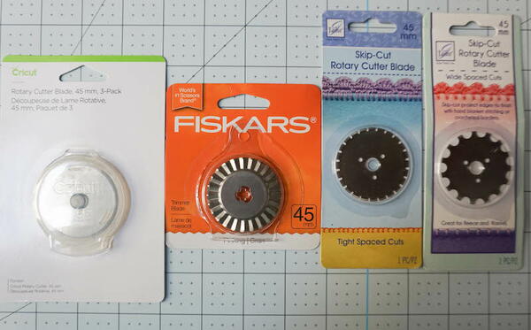Image shows four different rotary cutter blades in packaging.