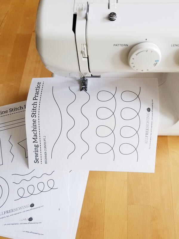Image shows a sewing machine with a practice sheet being sewn.