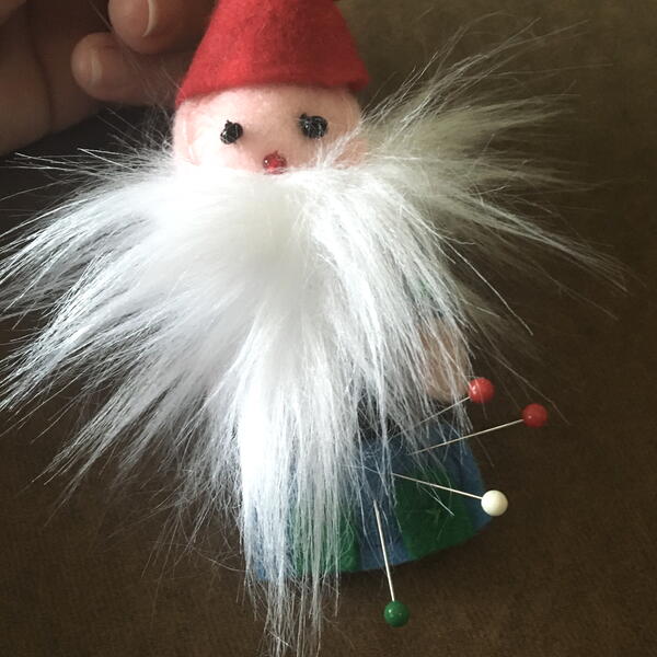 Image shows the finished gnome being used as a pincushion.