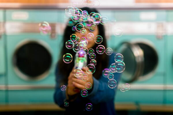 Woman in laundromat blowing bubbles