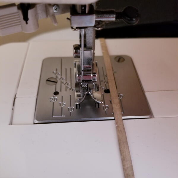 Add a rubber band to your sewing machine arm to create a custom seam allowance