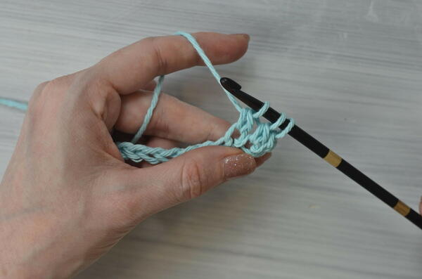 Image shows pulling through the first 2 loops on the hook for the Tunisian double crochet piece.