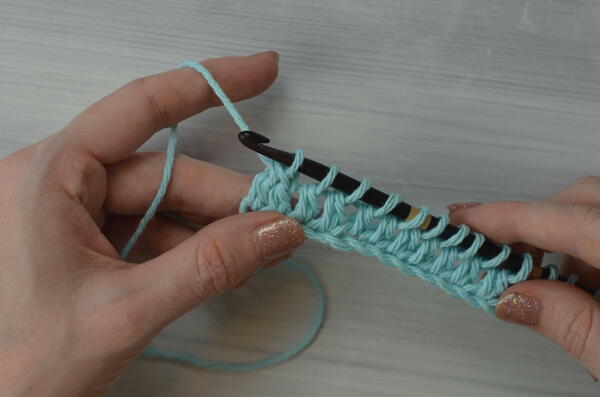 Image shows pulling through the first loop on the hook for the Tunisian double crochet piece.