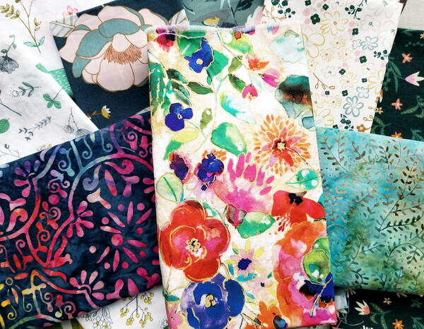 Image shows a stack of floral fabrics.
