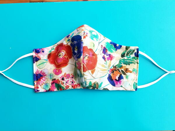 Image shows the finished floral fabric face mask.