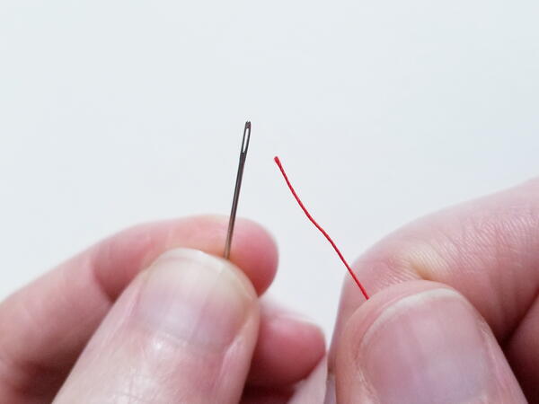 Threading a sewing needle: attempting to thread the needle