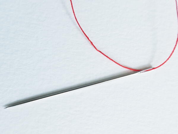 Threading a sewing needle: fully threaded needle