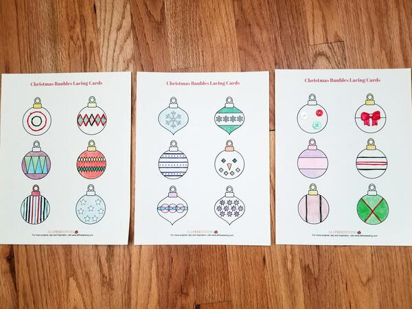 Image shows three sewing cards colored in and sewn with different-colored embroidery floss. Image shows three sewing cards colored in and sewn with different-colored embroidery floss.