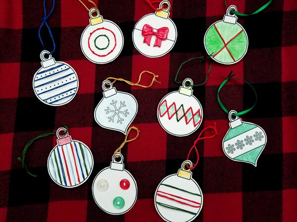 Image shows the colored in and sewn Christmas Baubles Printable Lacing Cards