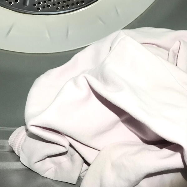 ​​​​​​​You never know when a manufacturer has pre-washed the clothing you purchase. Image shows a piece of clothing in a dryer.