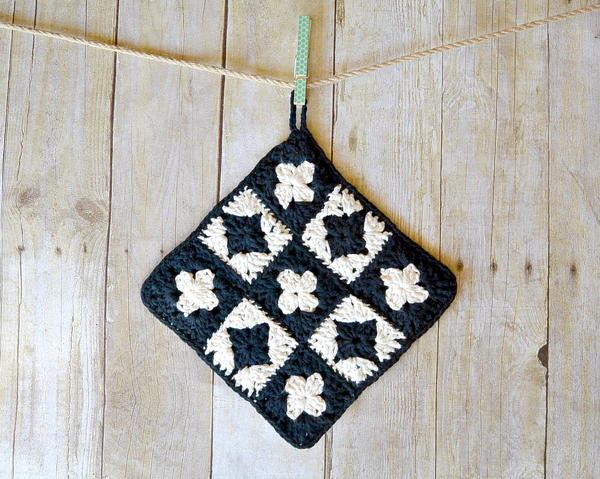 Image shows the Vintage Inspired Crochet Potholder hanging on a string attached to a wood wall.