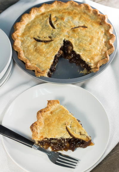 A slice of old-fashioned Amish Funeral Raisin Pie on a white plate.