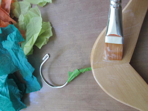 Brush a thin coat of decoupage medium onto the large center section of the hanger.