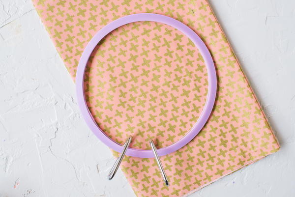 Image shows a plastic embroidery hoop on canvas