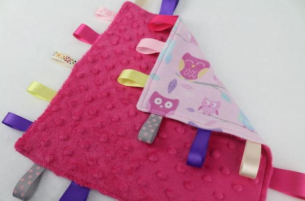 Image shows the finished tag blanket for babies.