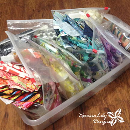 Storing Fabrics: Image shows stacks of scrap fabric in plastic bags in a storage tub.