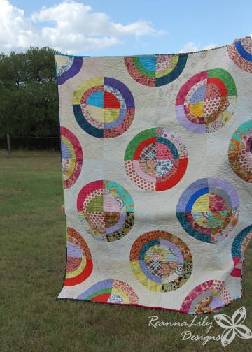 Image shows Jen's Scrappy Circles Quilt in full (photographed outside).