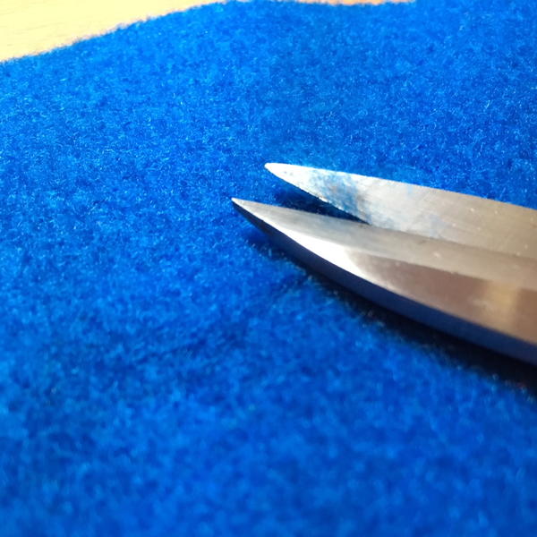 Fabric scissors trim loose fibers on craft felt