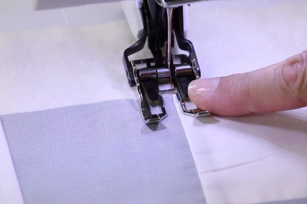 Image shows a machine sewing the stitch in a ditch design.