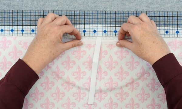 Image shows hands adjusting the pocket fabric over a ruler.