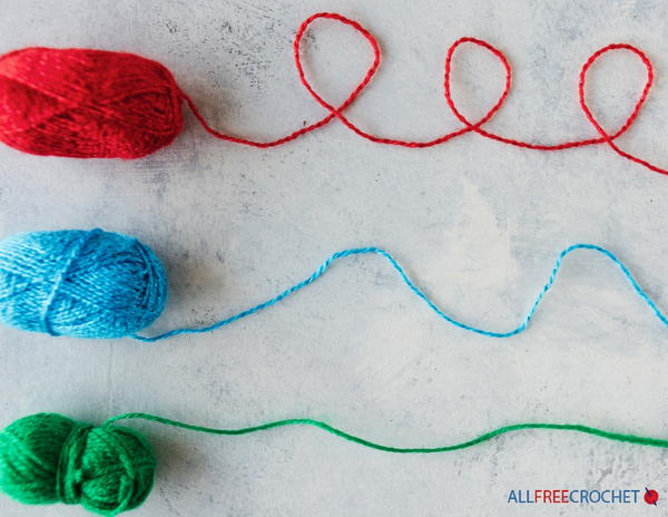 Image shows three skeins of yarn being unraveled.