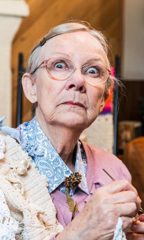 Woman crocheting while glaring at camera