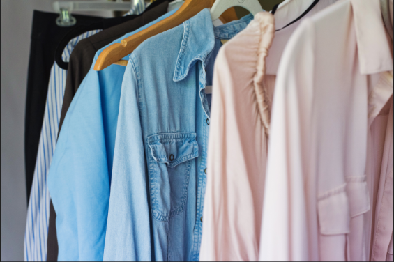 Image shows a close-up of a closet with various shirts hanging on hangers.