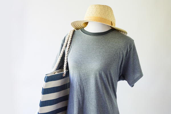 Image shows the finished men's shirt to women's shirt refashion on a mannequin with a hat and bag.