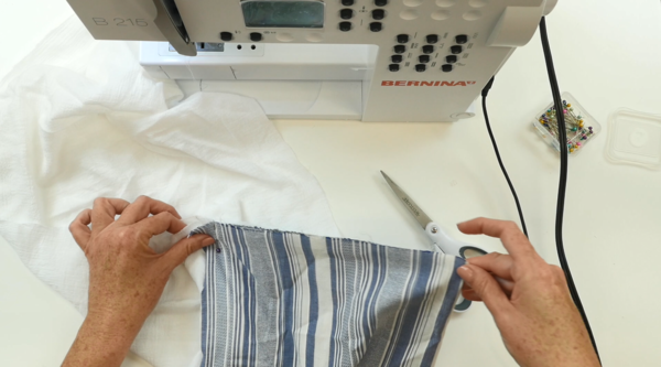 Image shows hands pinning a box pleat on the towel fabric.