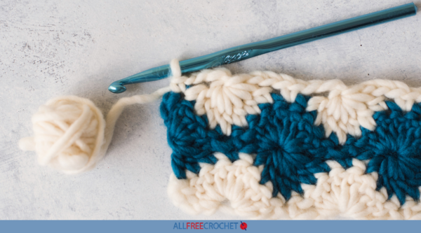Image shows a swatch of white and blue yarn showing the harlequin stitch.