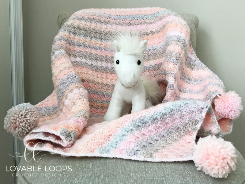 Cozy crocheted easy peasy baby blanket in soft yarn with simple texture