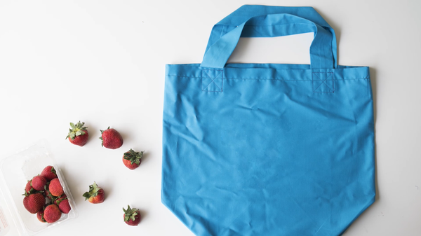 Image shows the finished bag on a white background. There are strawberries to the left of the bag.