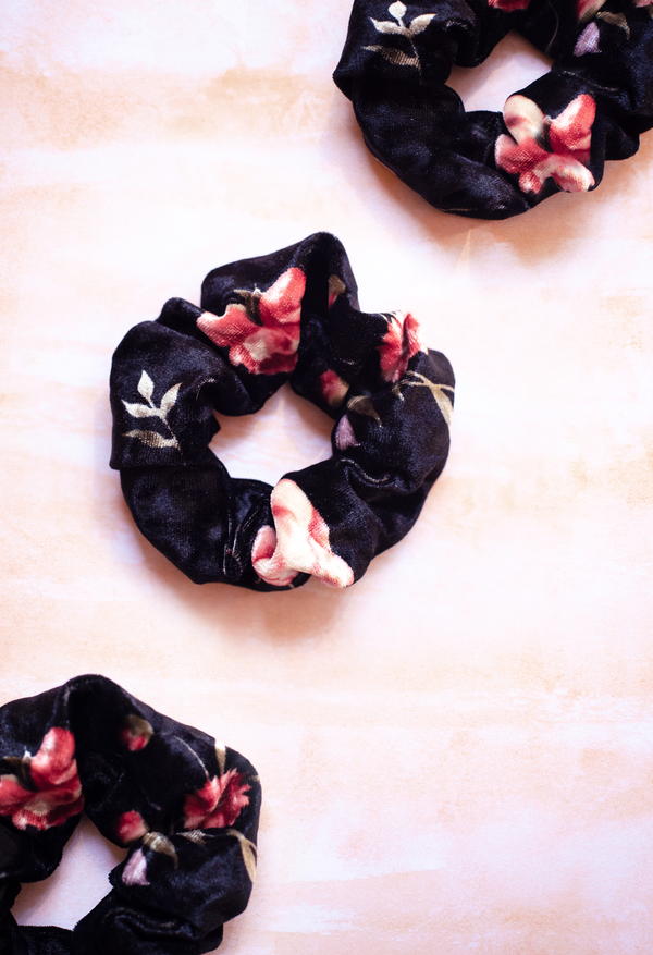 Image shows a close up of three scrunchies on a light pink background.
